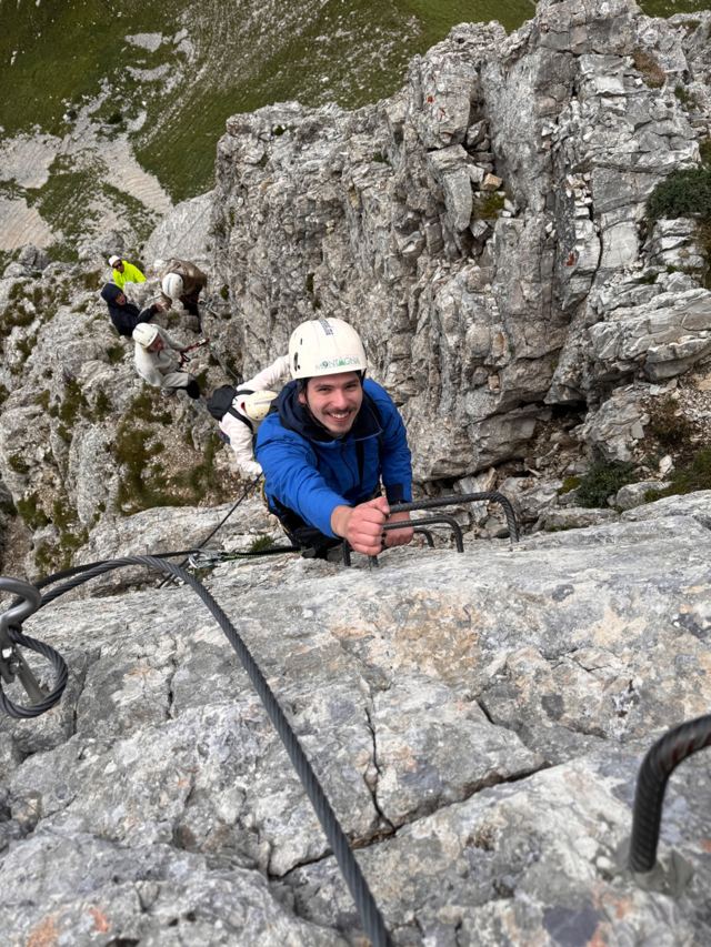 Climber pulling up on iron rungs, more of the group following below